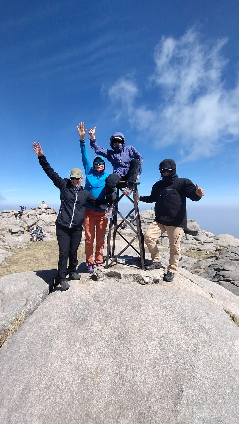 Grupo de excursionistas junto al marcador de la cumbre del Cerro Champaquí